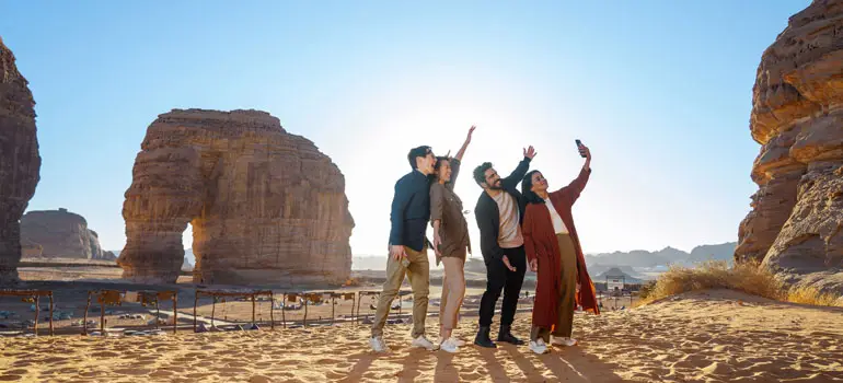 Friends taking a selfie in the desert rock formations of Saudi Arabia.