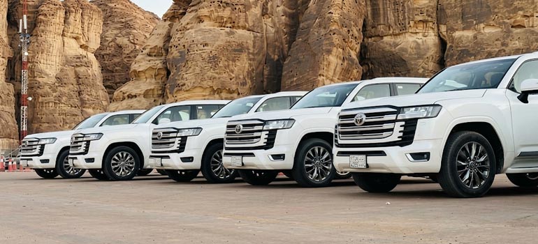 Fleet of white Toyota Land Cruisers for private transport and desert tours in Al Ula.