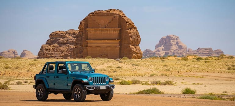 Jeep Wrangler private vehicle at Hegra archaeological site for Al Ula desert transport service.